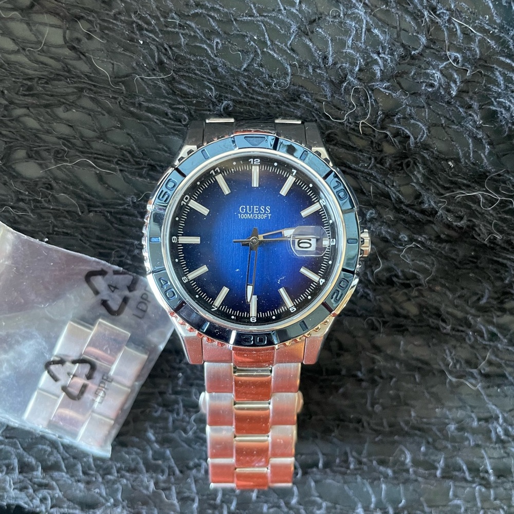 Women’s Guess Watch with blue face and crystals around perimeter.